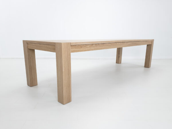 A white oak, square leg dining table with a cerused finish.