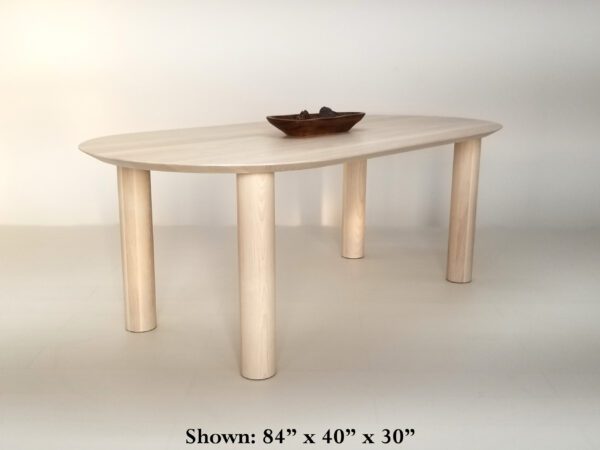 A oval dining table with round les and decor on top of it.