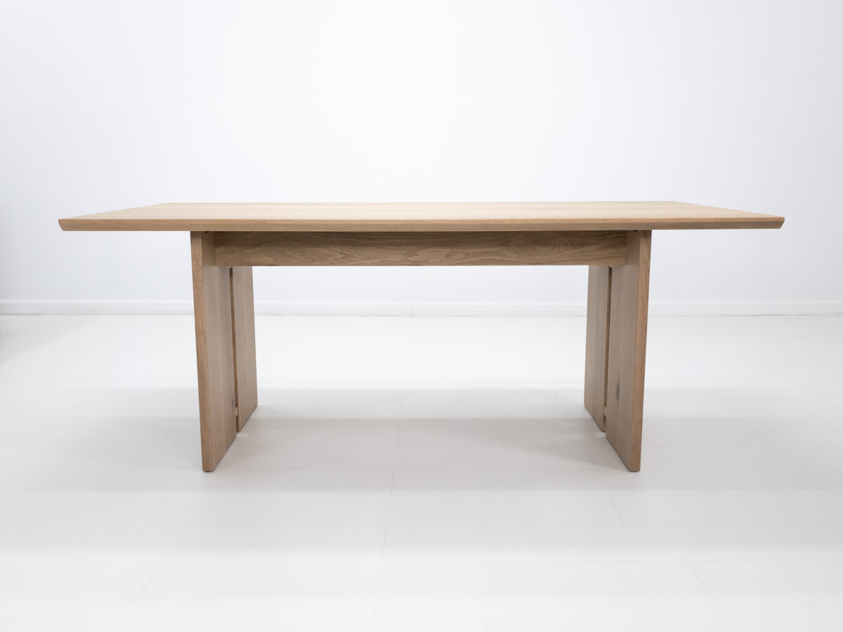 Side view of the DIVI dining table highlighting the beveled edge and natural wood grain finish