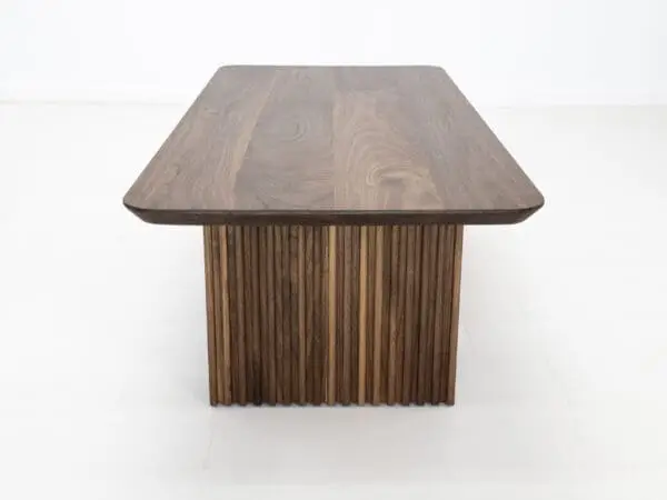 A walnut coffee table with ribbed legs.