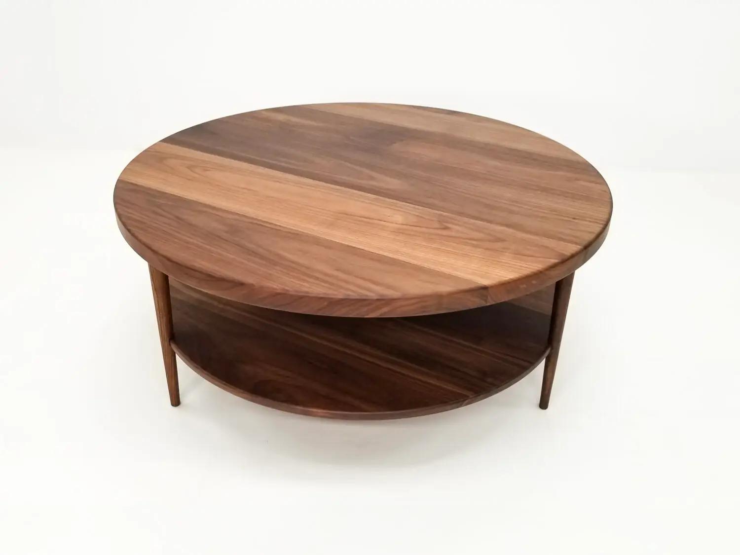 Handcrafted walnut coffee table featuring a 1⅜ inch thick round top with a smooth finish