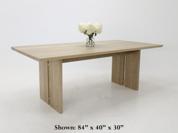 A panel table with split legs and flowers on top of it.