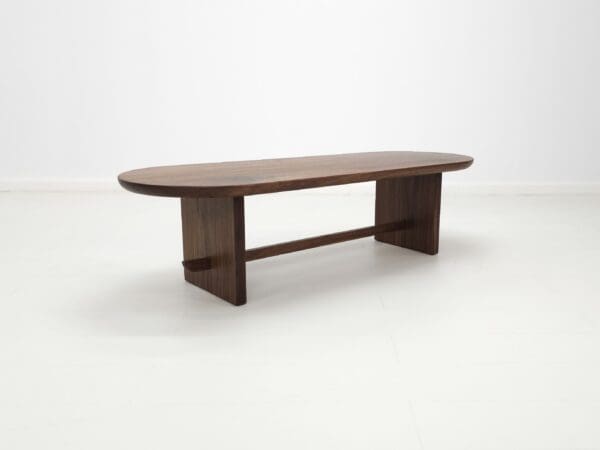 A solid walnut trestle coffee table.