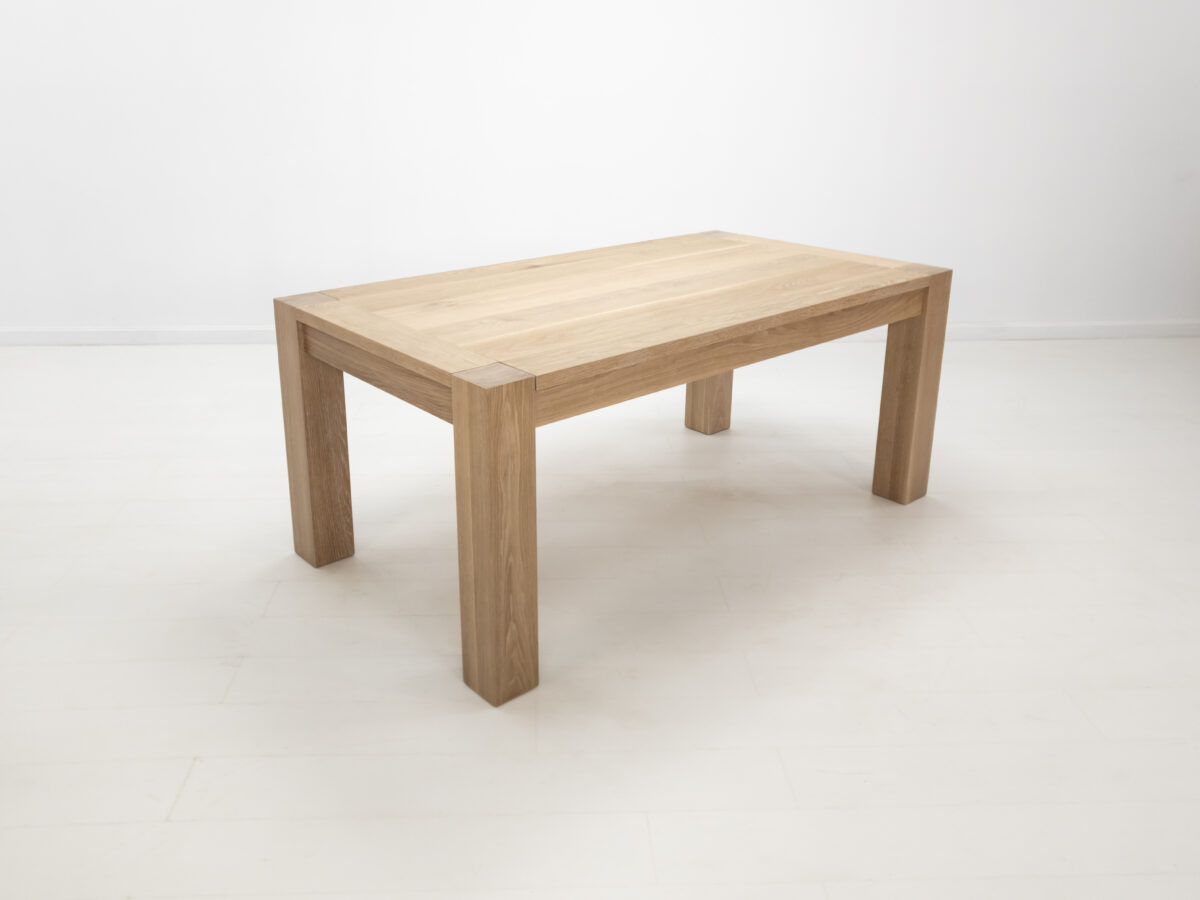 JAQI dining table in seawashed white oak finish featuring a seamless top with breadboard ends