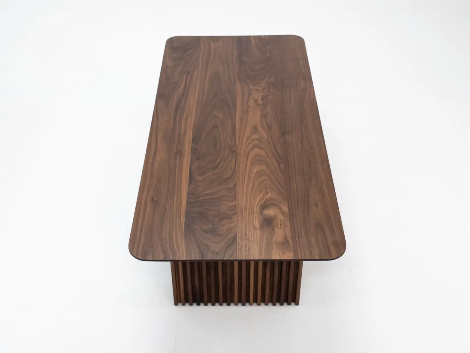 Top down view of the OWEN coffee table highlighting the seamless walnut grain and beveled edge