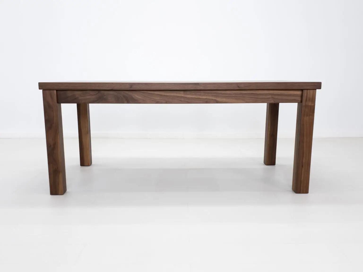 A parsons style walnut dining table