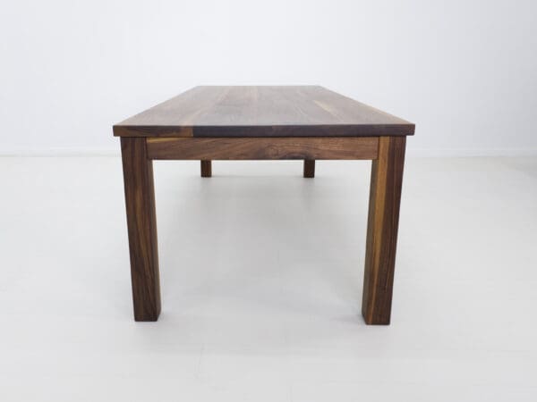 A close up image of a walnut dining table.