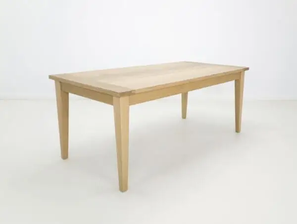 A white oak dining table with tapered legs.