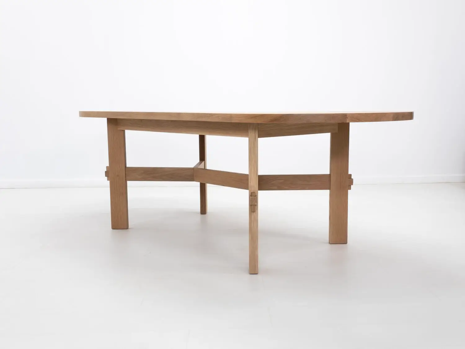 Side view of the COLT dining table showing exposed mortise and tenon joinery with locking pegs