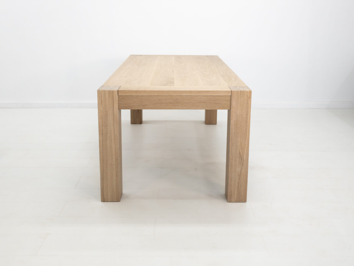 JAQI dining table in seawashed white oak finish featuring a seamless top with breadboard ends