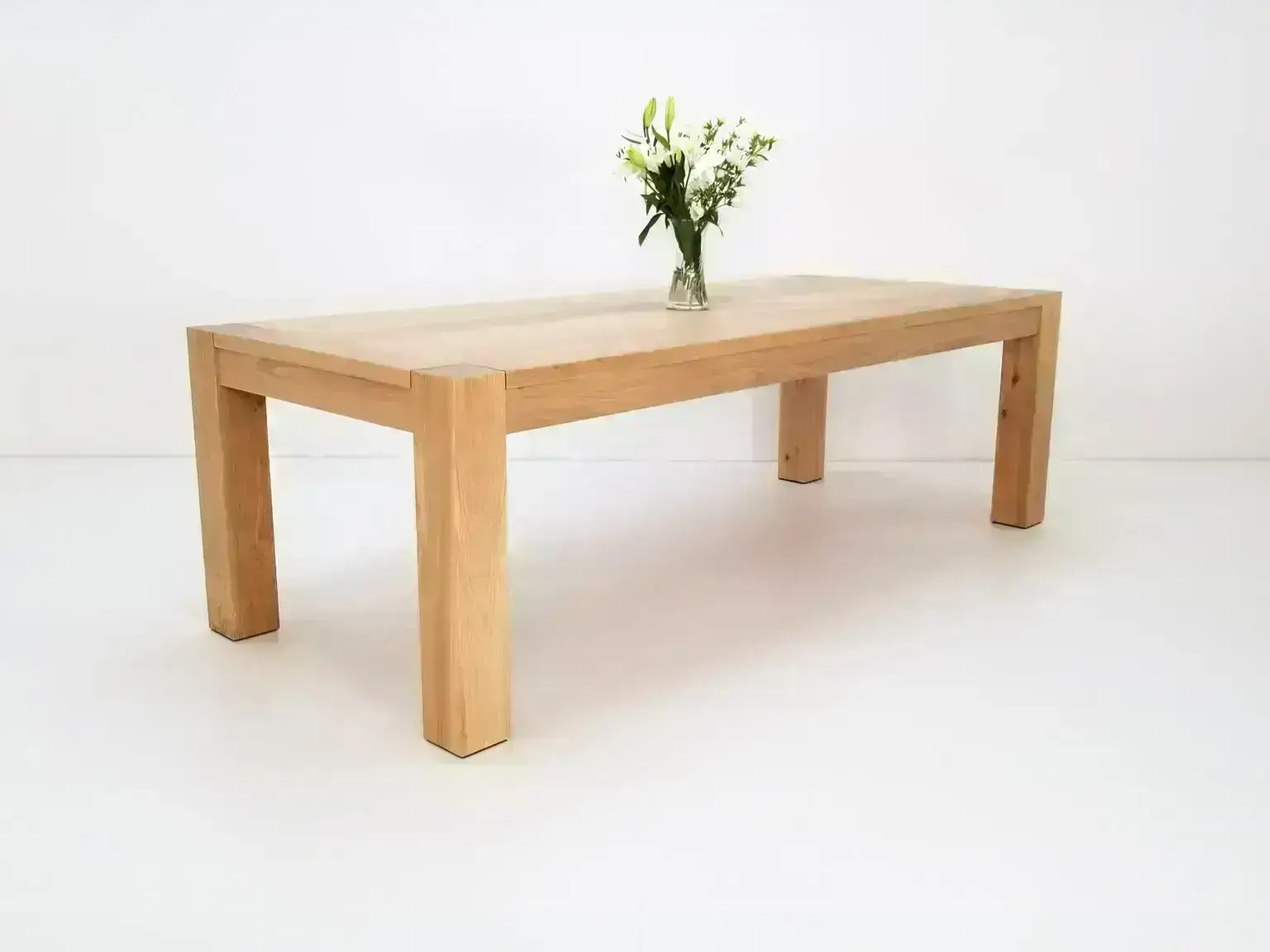 Colossal leg JAQI dining table in natural white oak showcasing its clean lines and sturdy design