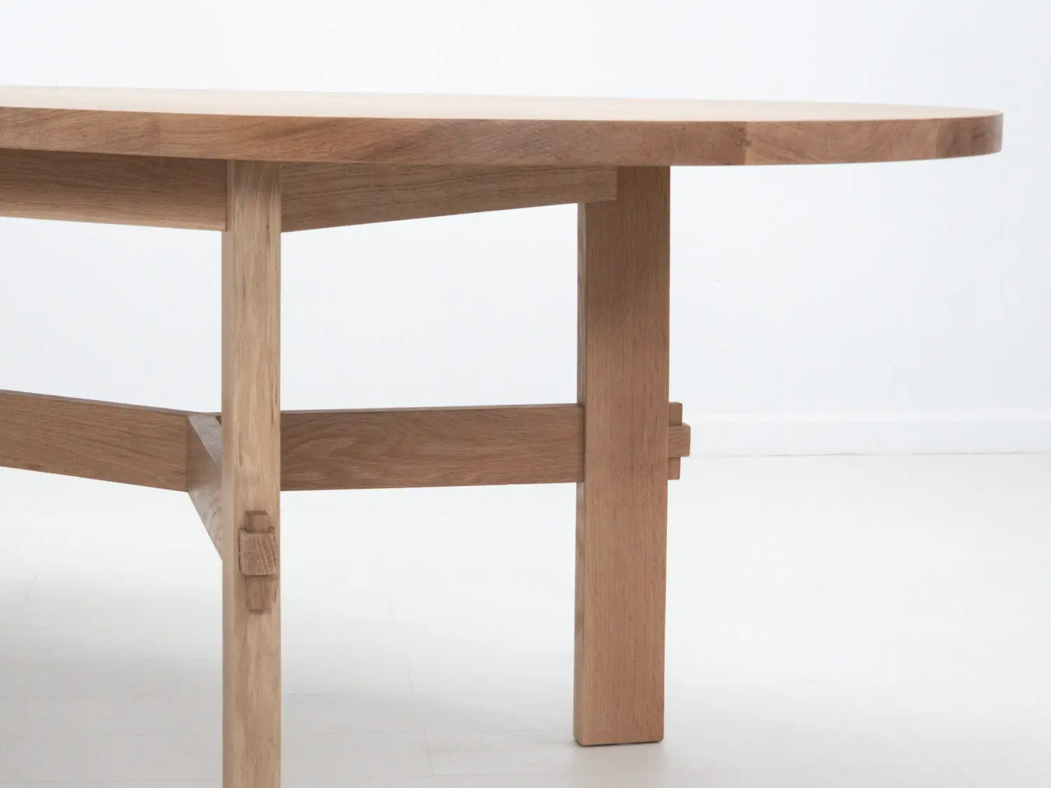 Side view of the COLT dining table showing exposed mortise and tenon joinery with locking pegs