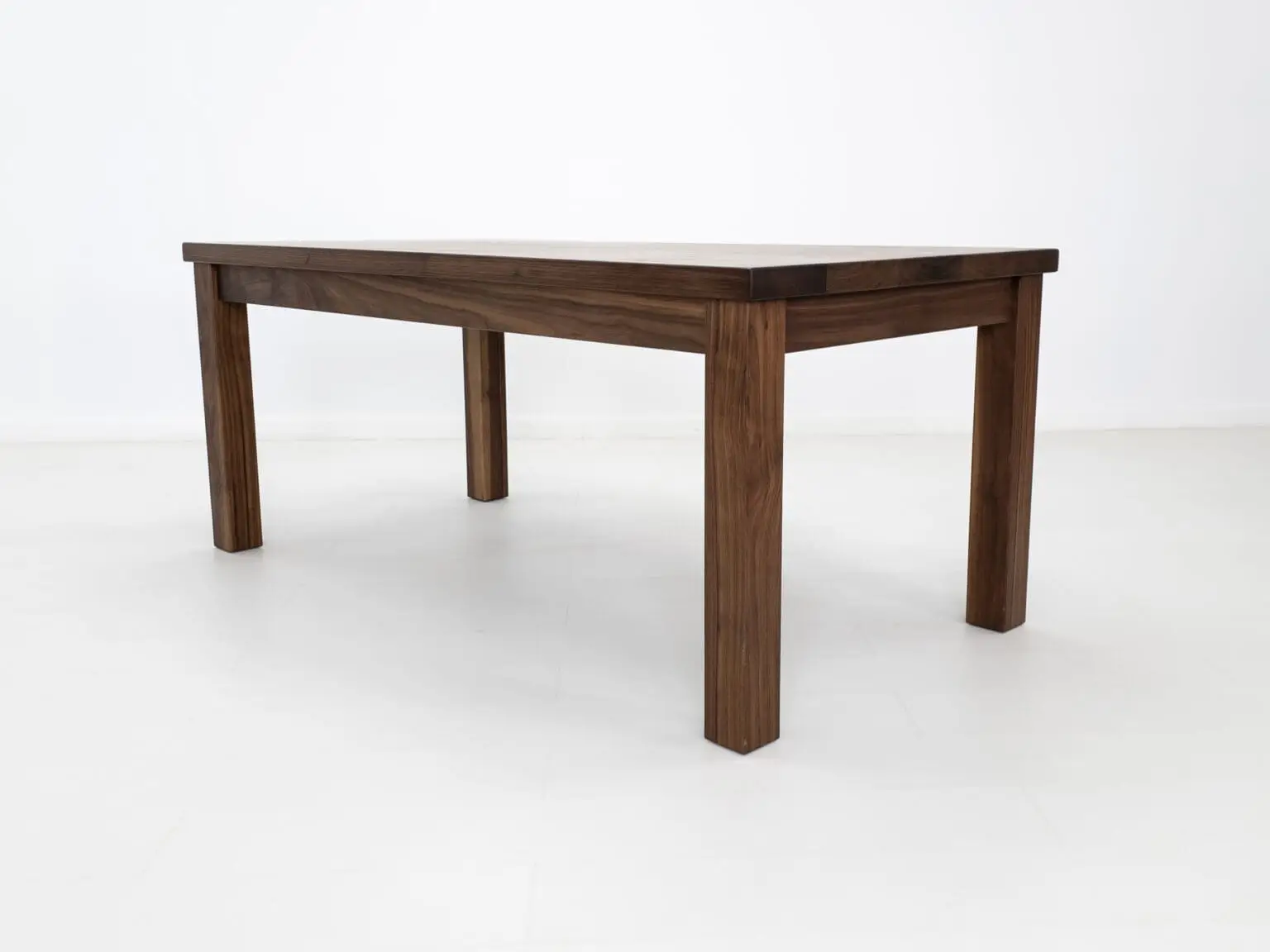 A parsons style walnut dining table