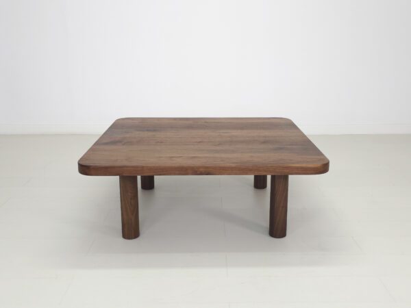 A walnut coffee table with four legs.