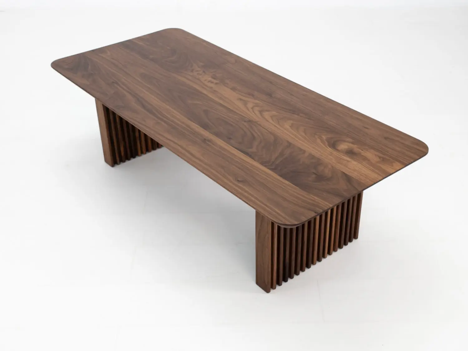 Top down view of the OWEN coffee table highlighting the seamless walnut grain and beveled edge