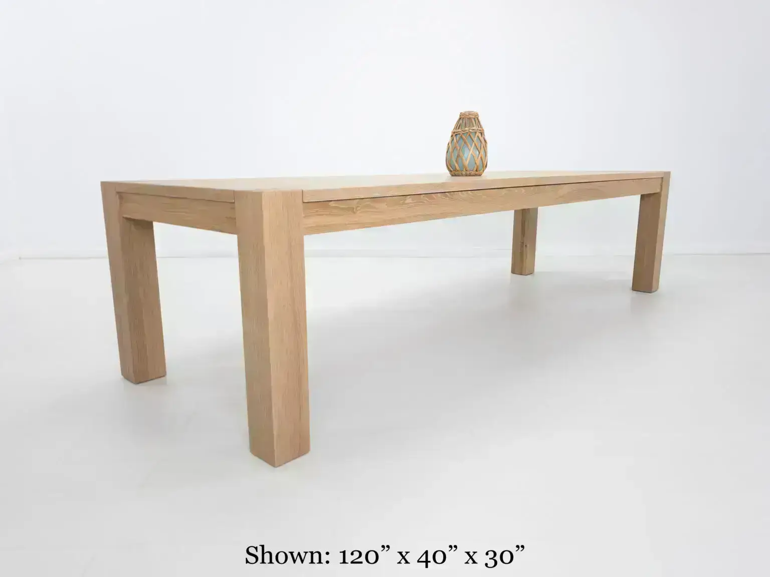 JAQI dining table in seawashed white oak finish featuring a seamless top with breadboard ends