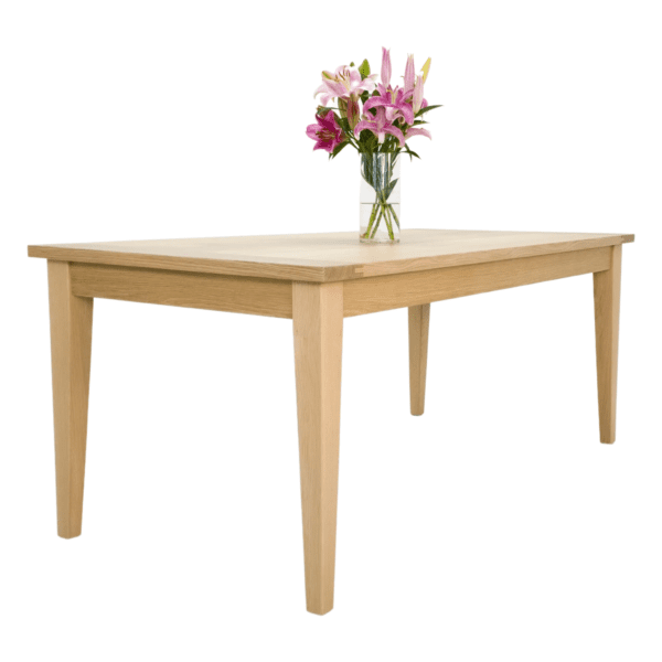 A wooden table with a vase of flowers on it.