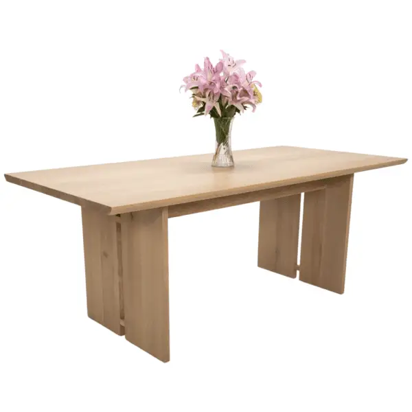 Light wood dining table with flowers.