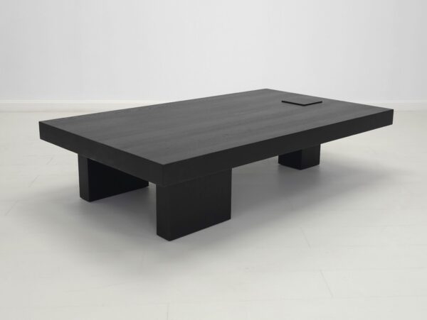 A unique black coffee table with three legs.