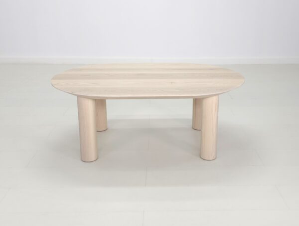A custom COVE Coffee Table with two legs in a white room.