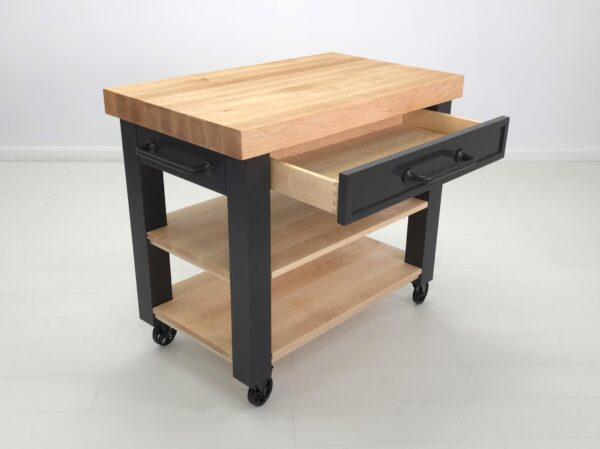 An angled shot of a butcher block kitchen cart with a shaker styled drawer.