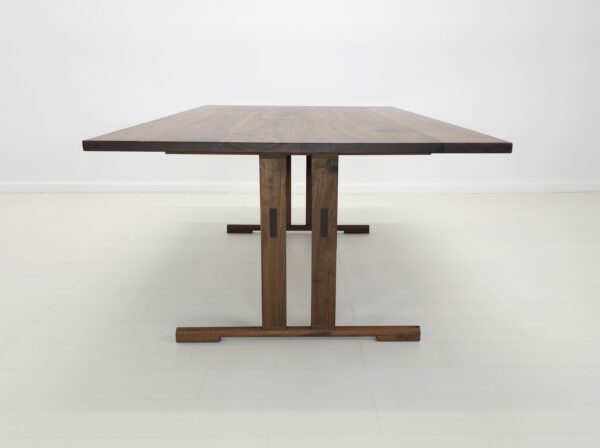 A walnut trestle dining table.
