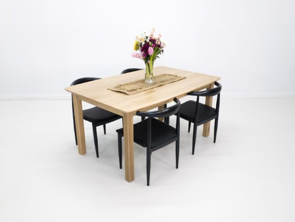 A ribbed leg dining table with seating around it.