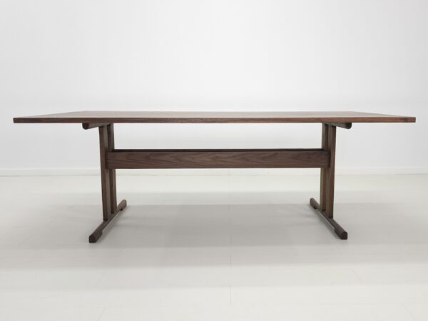 A walnut trestle dining table.