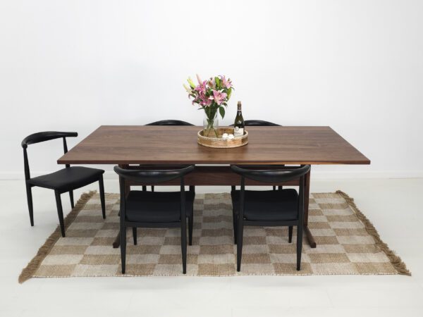 A walnut dining table with chairs around it.