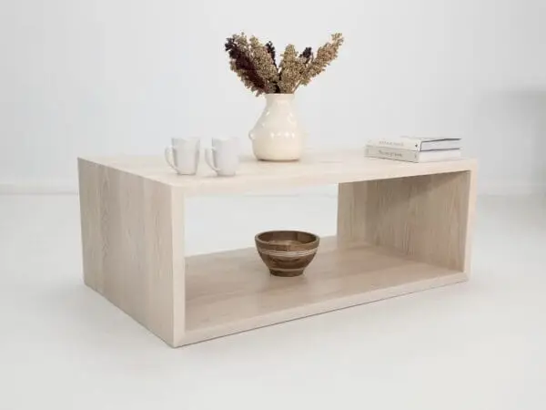 A rectangular coffee table with decor on top of it.