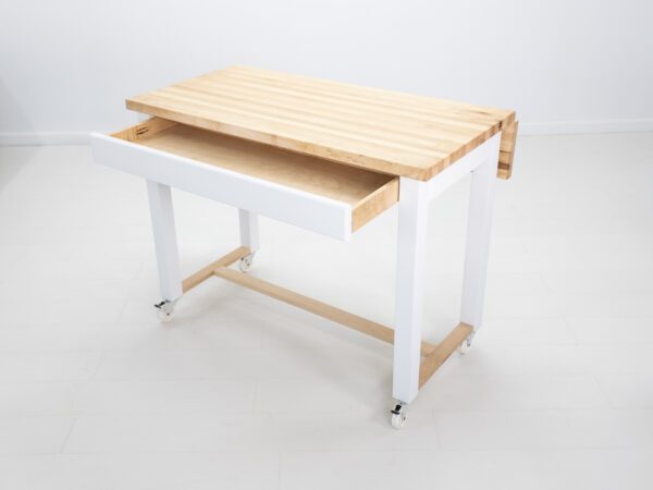 A butcher block kitchen island with room for seating a drawer open.