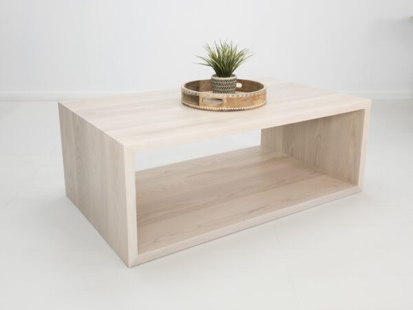 A rectangular coffee table with decor on top of it.