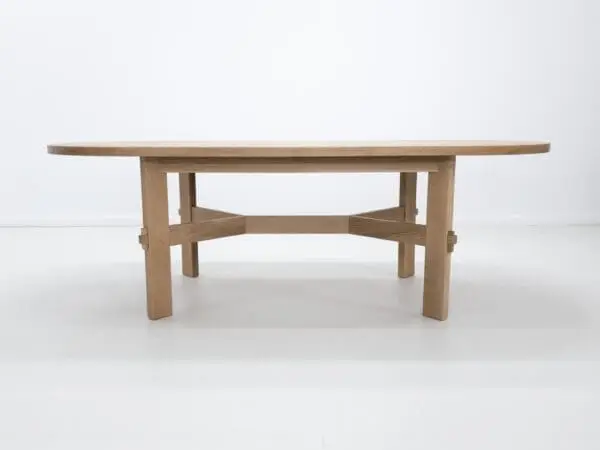 A white oak dining table with an angular stretcher design.