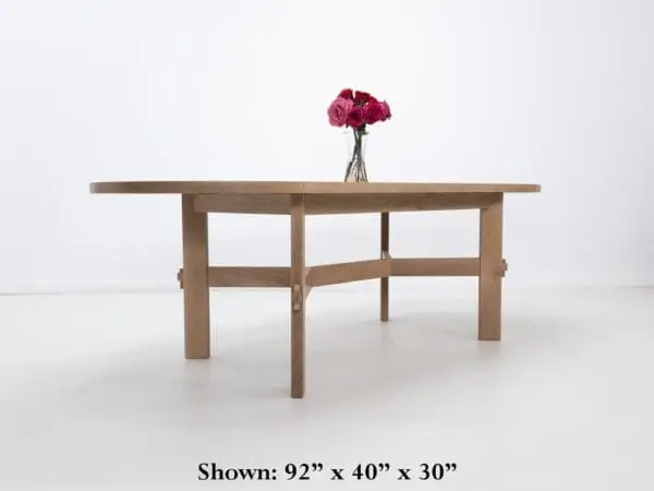 A white oak dining table with an angular stretcher design.