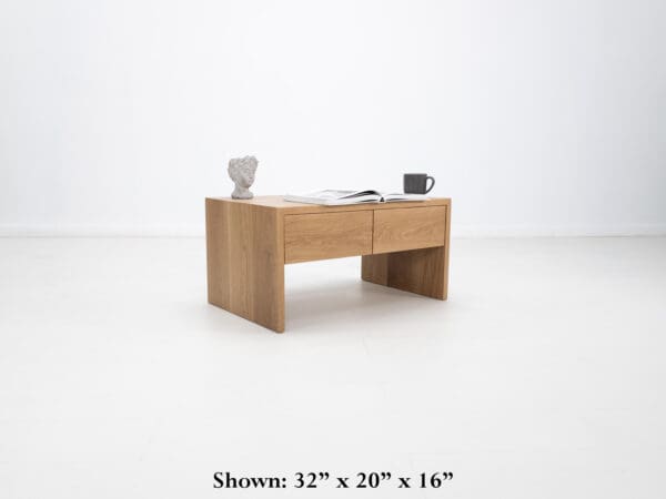 A continuous grain coffee table with drawers and decor on top of it.