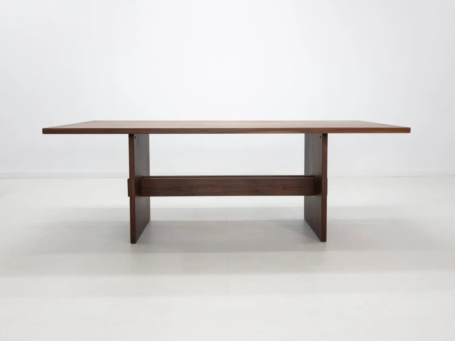 Solid walnut trestle dining table with a 1⅜ inch thick top