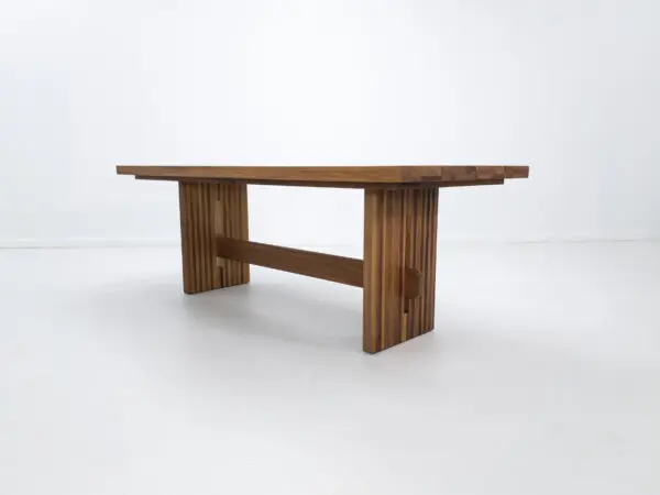 A outdoor table with a a slated top and a trestle base.