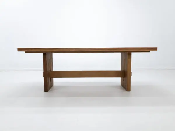 A outdoor table with a a slated top and a trestle base.