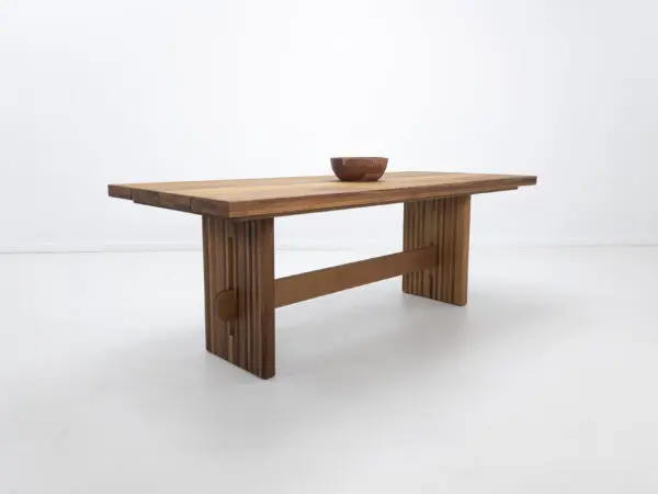 A outdoor table with a a slated top and a trestle base.