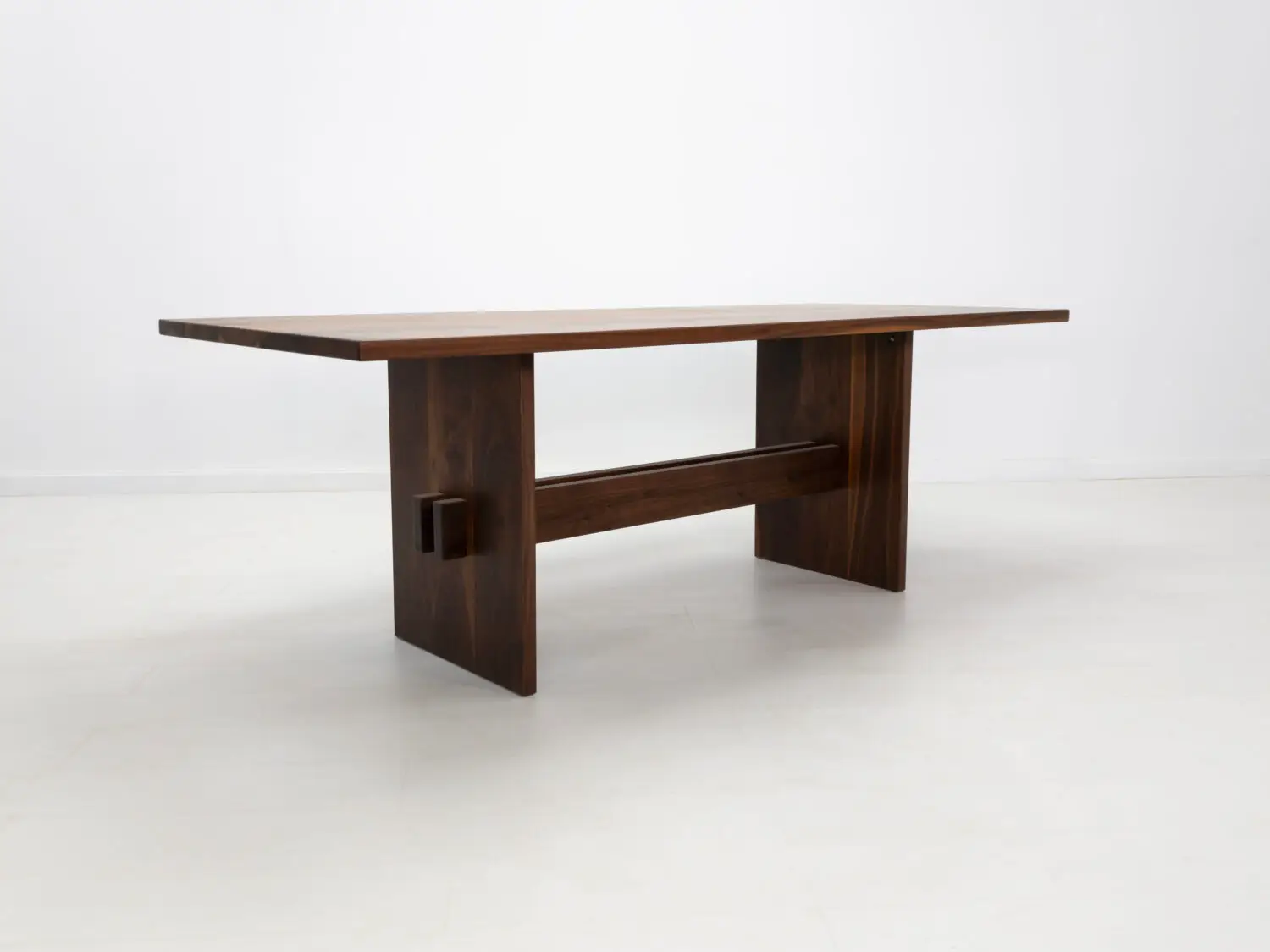 Solid walnut trestle dining table with a 1⅜ inch thick top