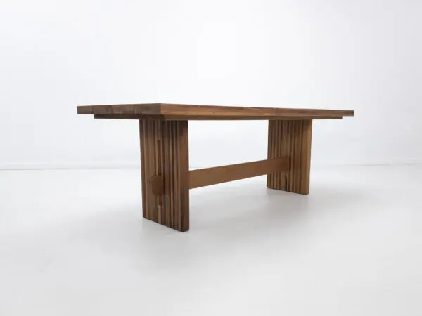 A outdoor table with a a slated top and a trestle base.