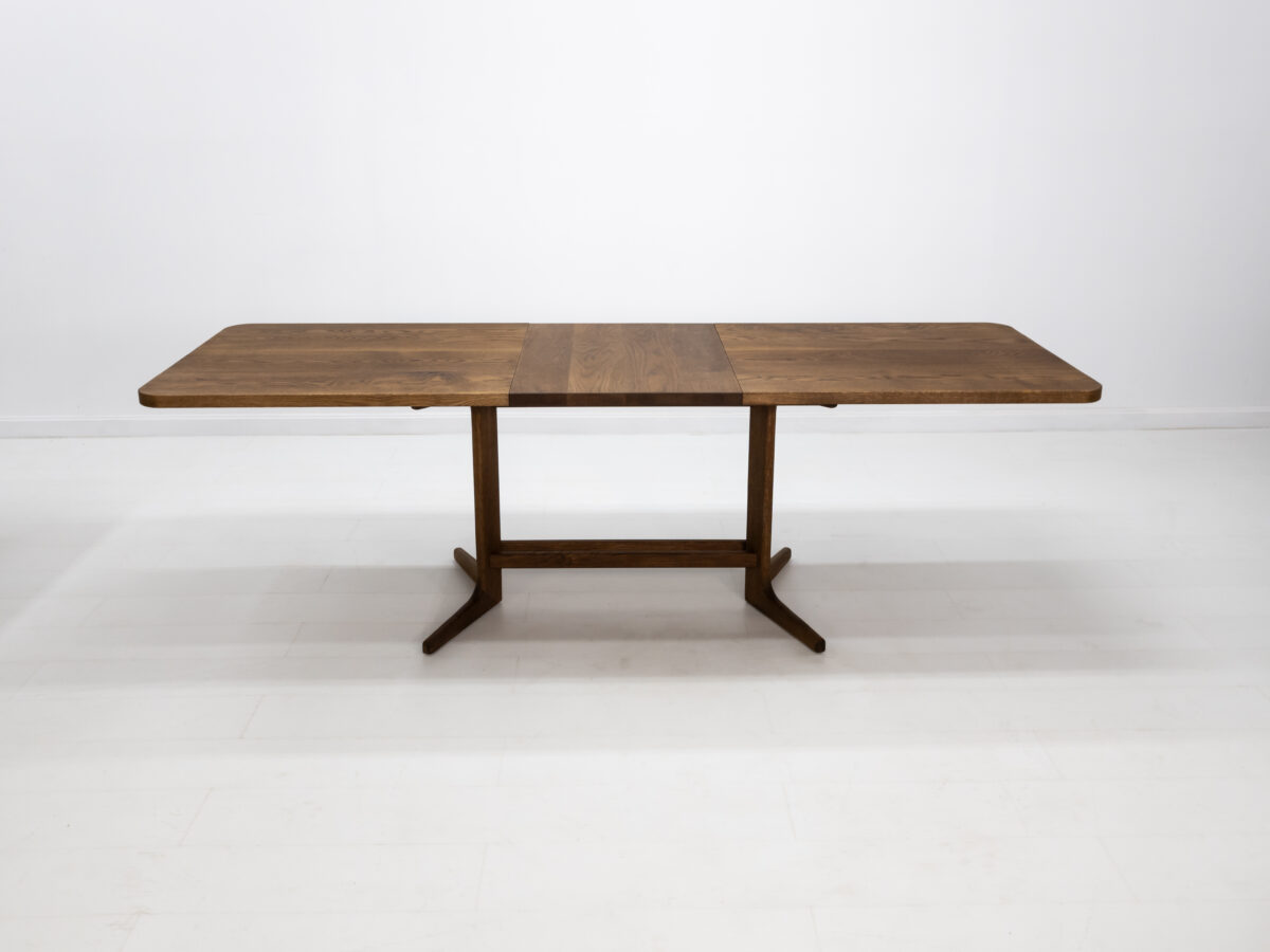 BRIA table with a sleek trestle base and optional 22 inch leaf extension in white oak