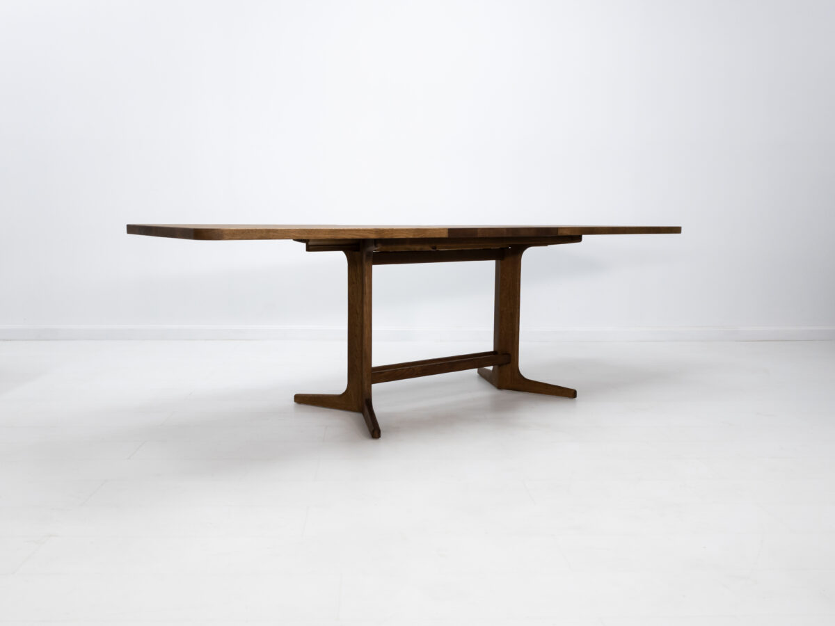 BRIA table with a sleek trestle base and optional 22 inch leaf extension in white oak