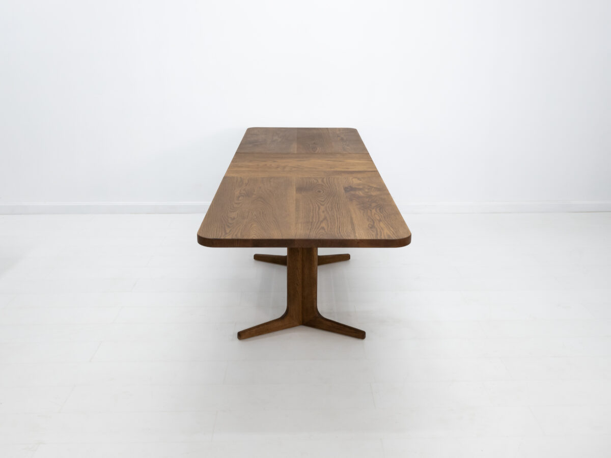 BRIA table with a sleek trestle base and optional 22 inch leaf extension in white oak