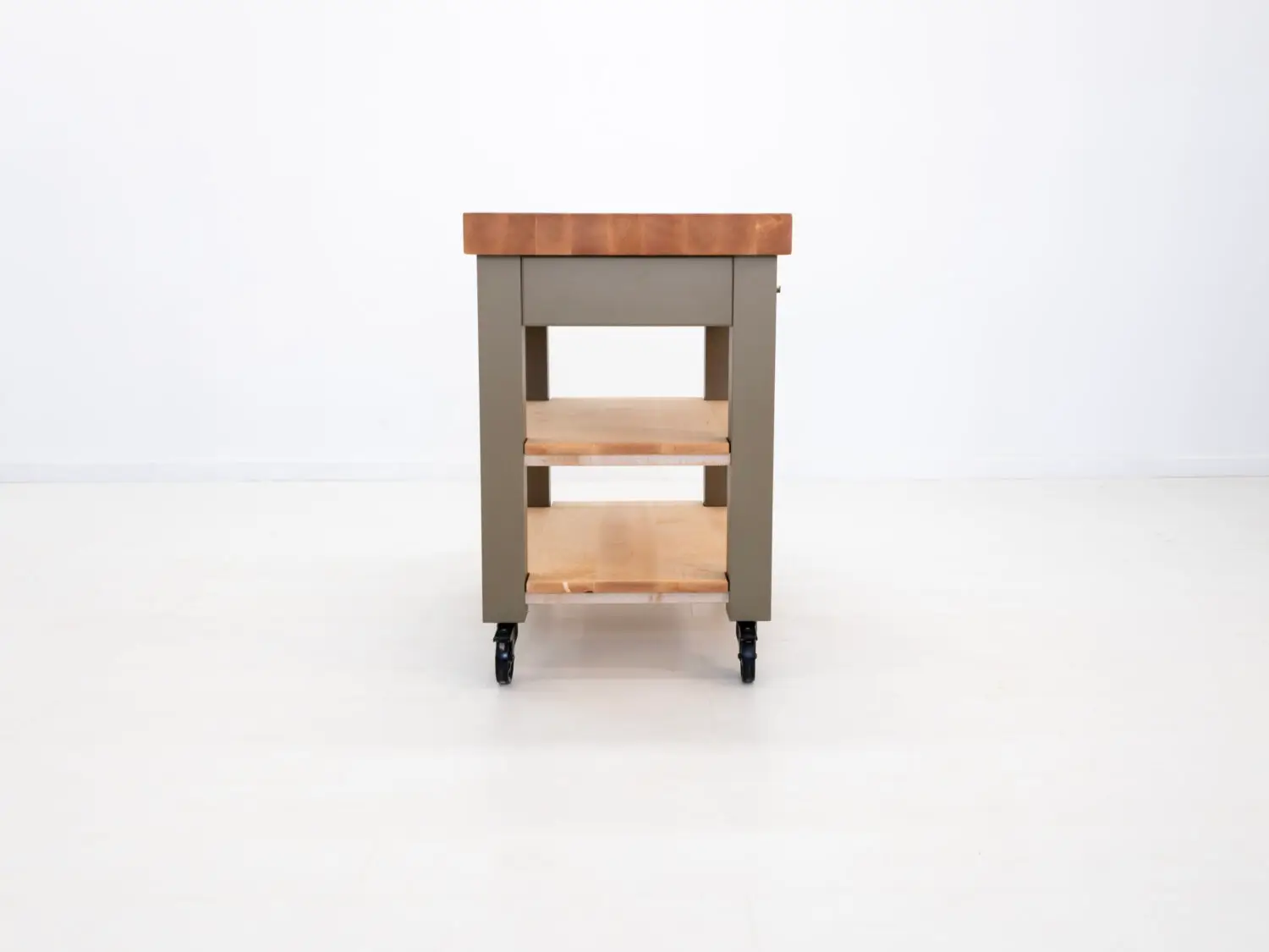 Maple butcher block cart with a cutting board knife and fresh produce styled for a functional kitchen setting