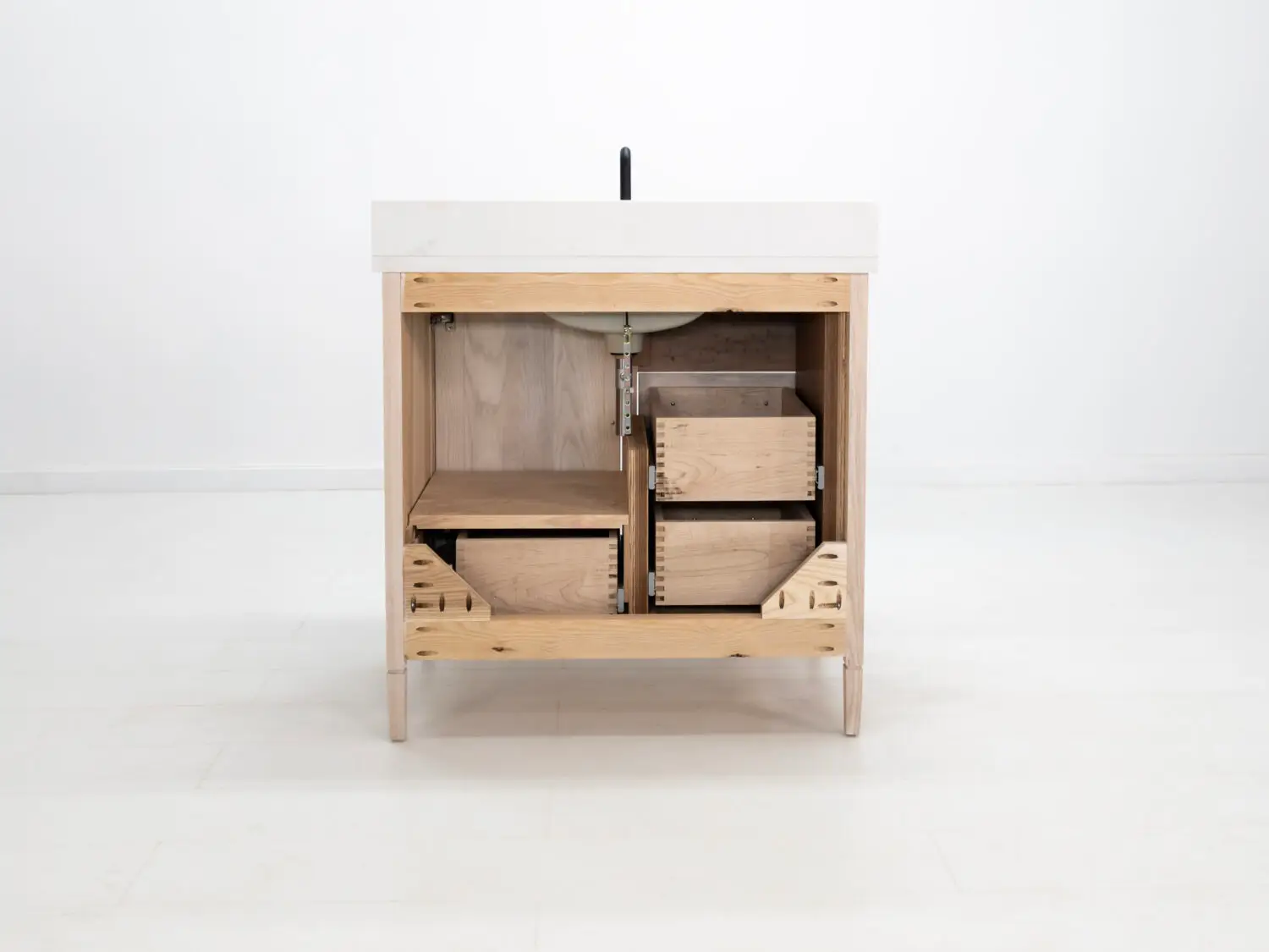 Light ashwood vanity featuring a faux top drawer face and additional storage